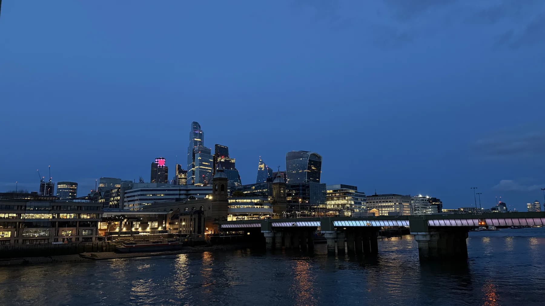 A city skyline reflected in a river at blue hour